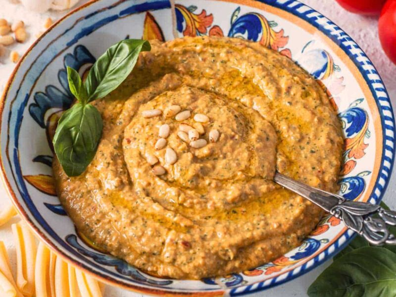 Cremiges Pesto alla Siciliana in einer dekorativen Keramikschale, garniert mit Basilikum und Pinienkernen.