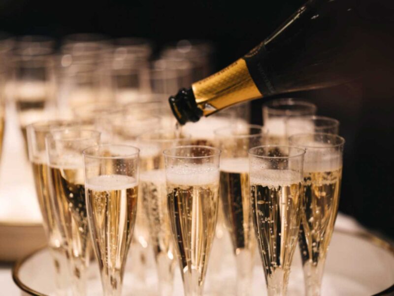 Eine Flasche Prosecco wird in elegante Sektgläser gegossen, während feine Perlen aufsteigen – ein Symbol für italienische Eleganz und Genussmomente.